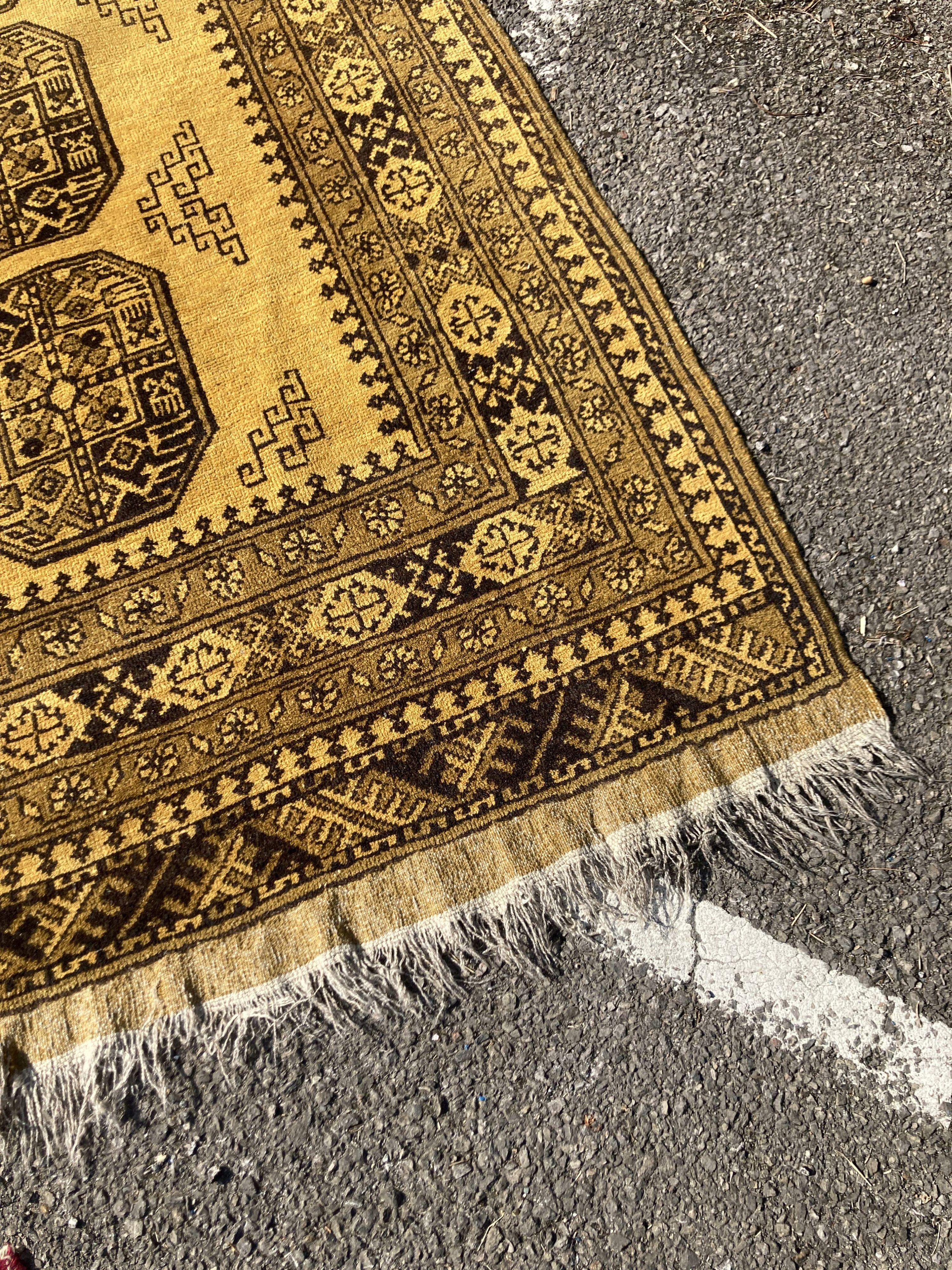 An Afghan gold ground carpet, 300 x 200cm